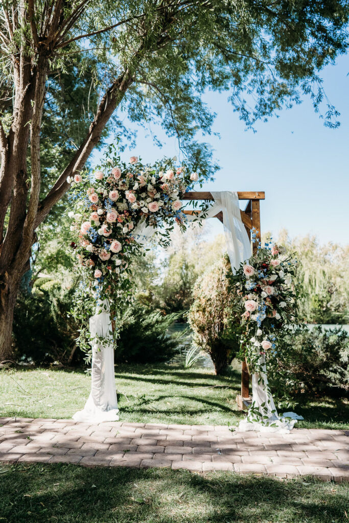 pink roses and blue bells wedding flower, wedidng flowers on arch, windmill house arizona