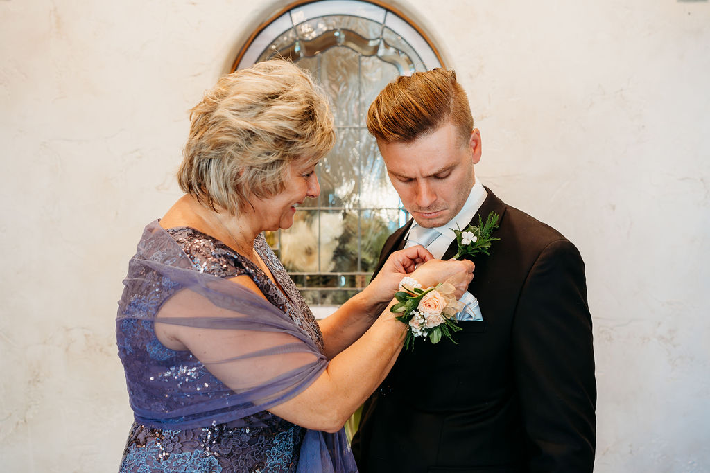 mom pinning boutonnière, mom of the groom