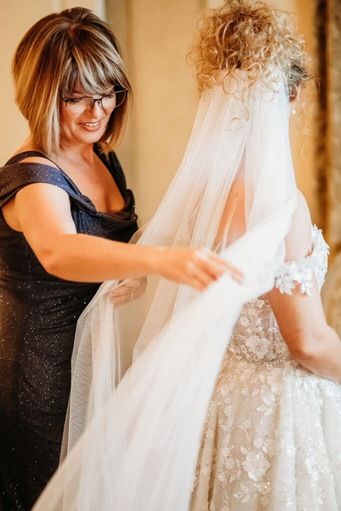 mom of the bride, mom helping bride getting ready, mom fluffing veil