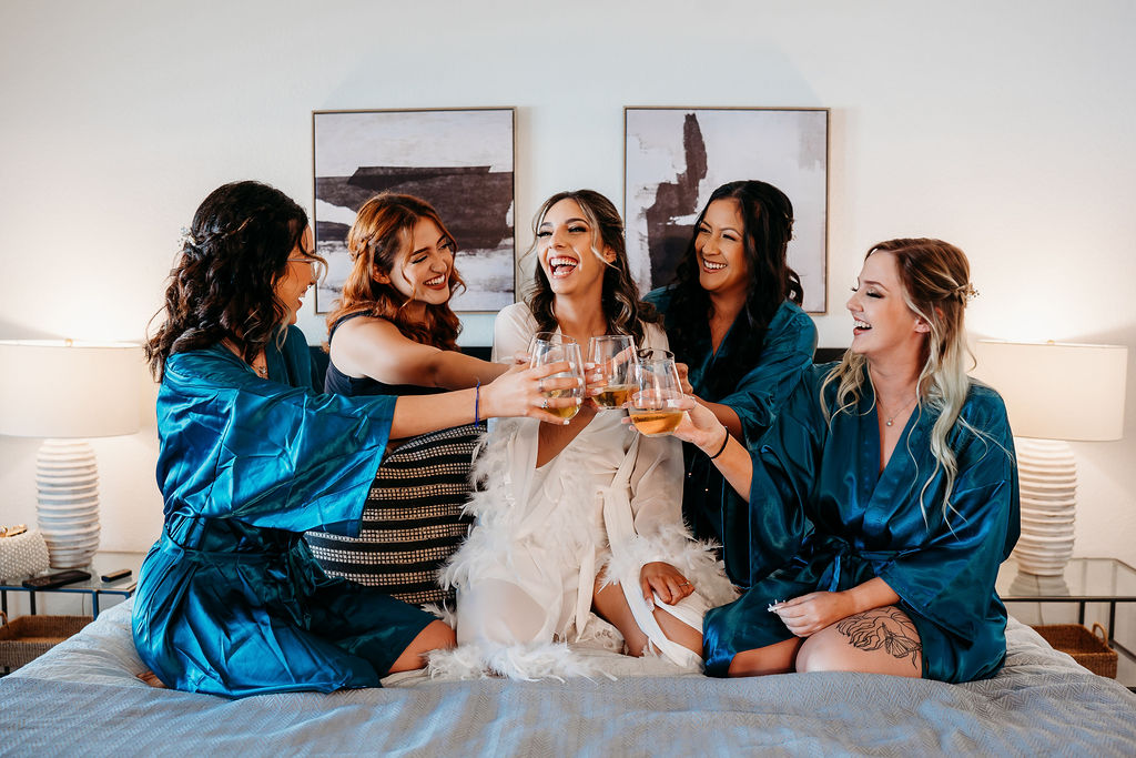 bride and bridal party in robes with champagne