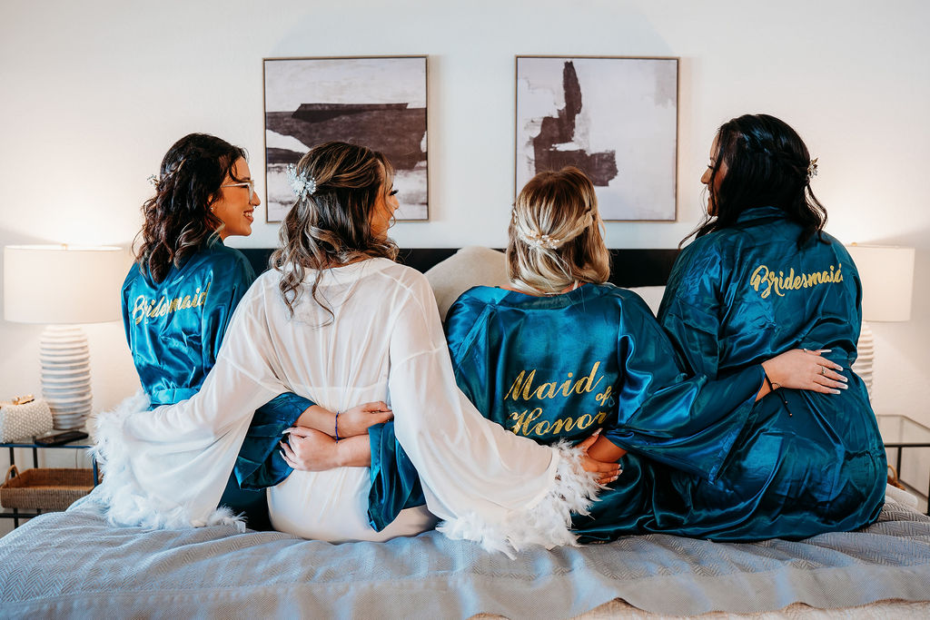 bride and bridal party in robes with champagne