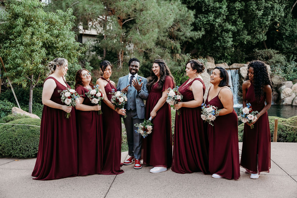 groom with bridal party portraits at Japanese Friendship Garden Arizona. bridal party in maroon dresses