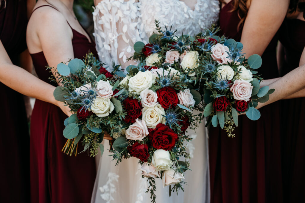 Wedding bouquet f maroon roses, blush roses and white rose. 