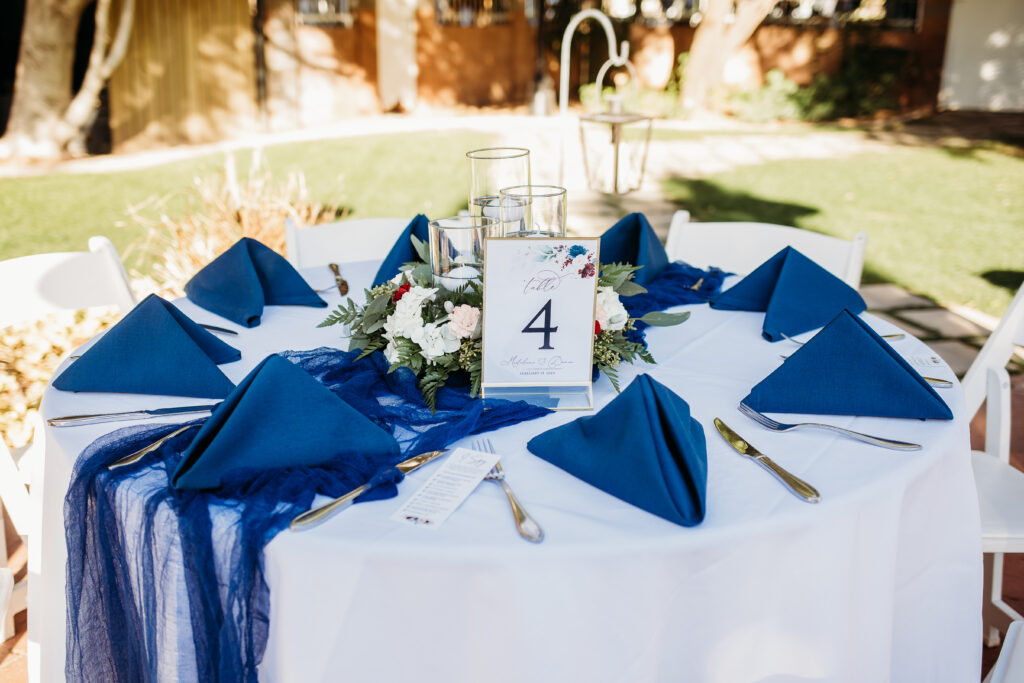 Wedding details at Stonebridge Manor. Wedding table setting of navy blue and maroon. 