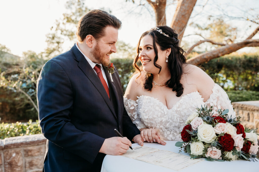 Bride and groom signing marriage certificate.