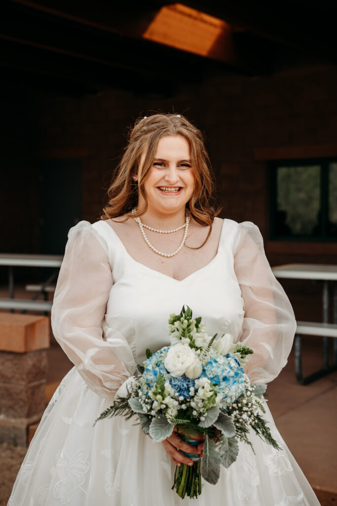 Bride first look with bridesmaids, white roses and blue hydrangea bouquet