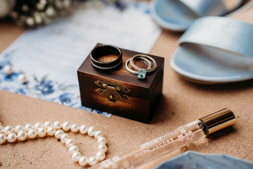 Ring shots at wedding, rose gold wedding ring with a baby blue stone, ring box. 