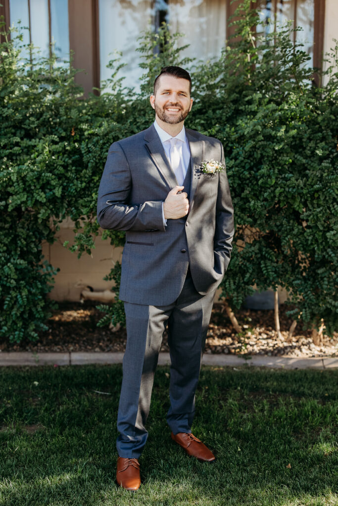 Groom in grey suit at secret garden, arizona wedding photographer