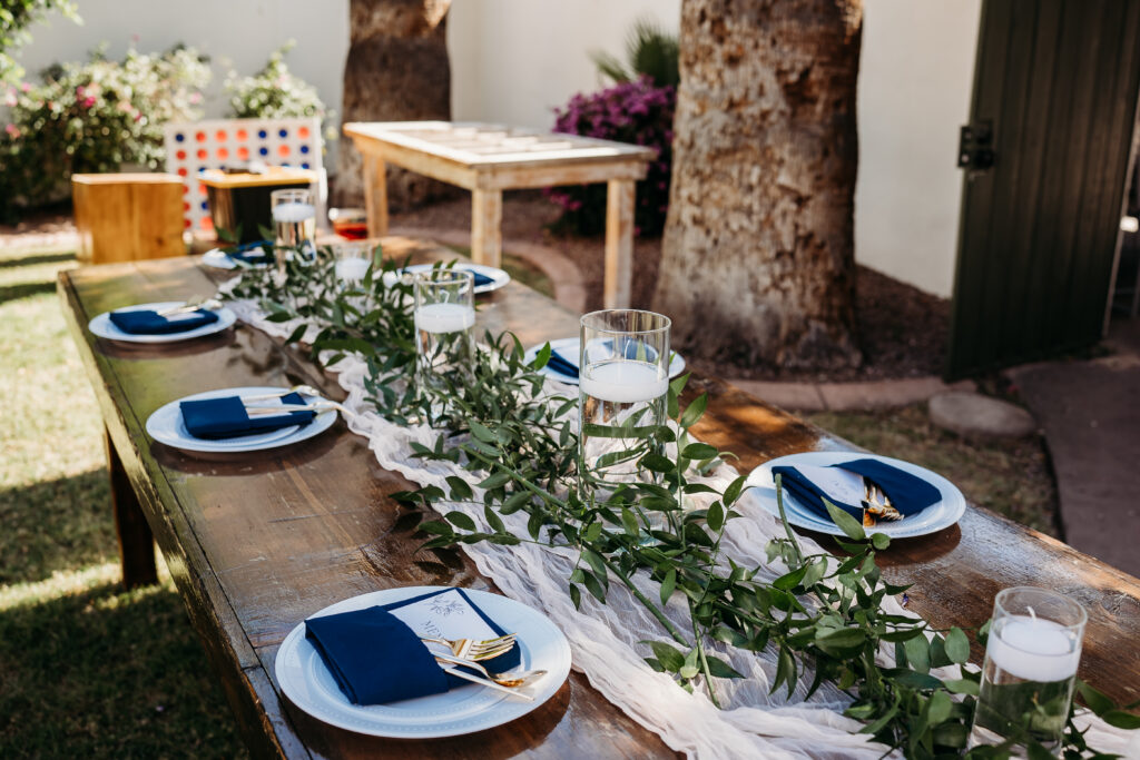 outdoor intimate reception, navy and gold table setting, farmhouse tables for wedding reception