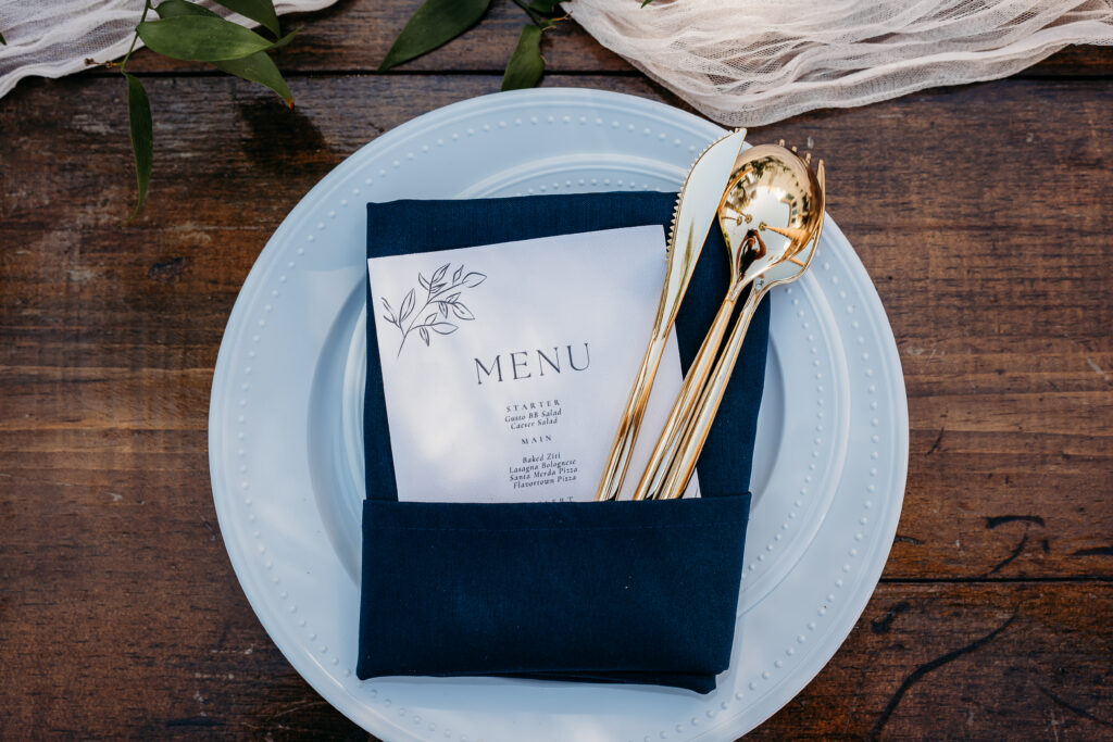 table setting and menu for wedding, navy blue and gold table setting