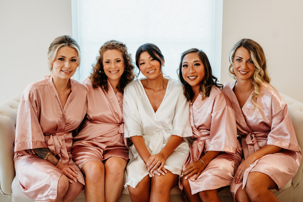 bride and bridesmaids in silk robes, getting ready for wedding