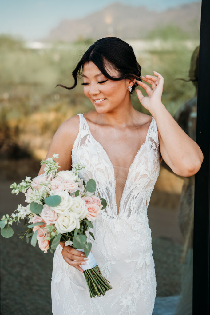 bride holding pink and white rose bouquet, bridal portraits, bride posing ideas, deep v neck wedding dress with floral details