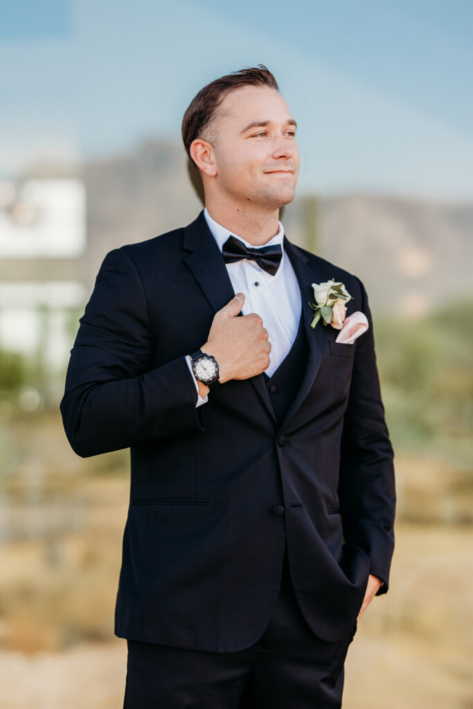 groom in black tux, groom with pink rose boutonniere, groom posing ideas