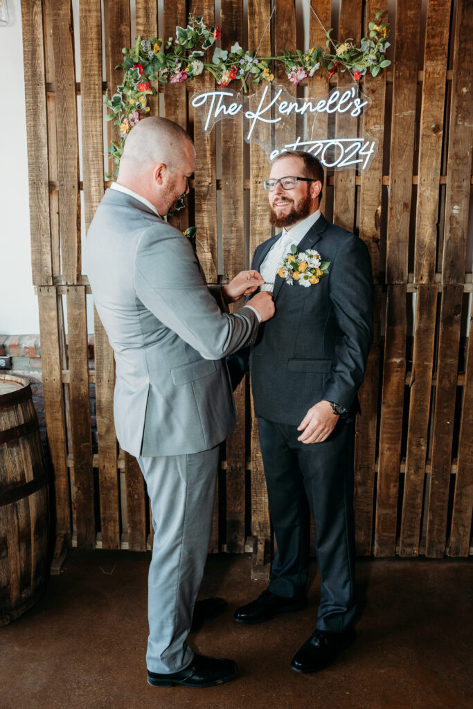 Groomsmen in grey tux and orange tie, bright boutonniere, wedding party posing ideas, arizona wedding photographer