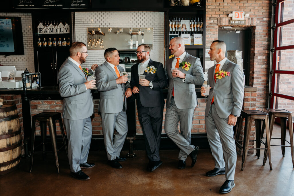 Groomsmen in grey tux and orange tie, bright boutonniere, wedding party posing ideas, arizona wedding photographer