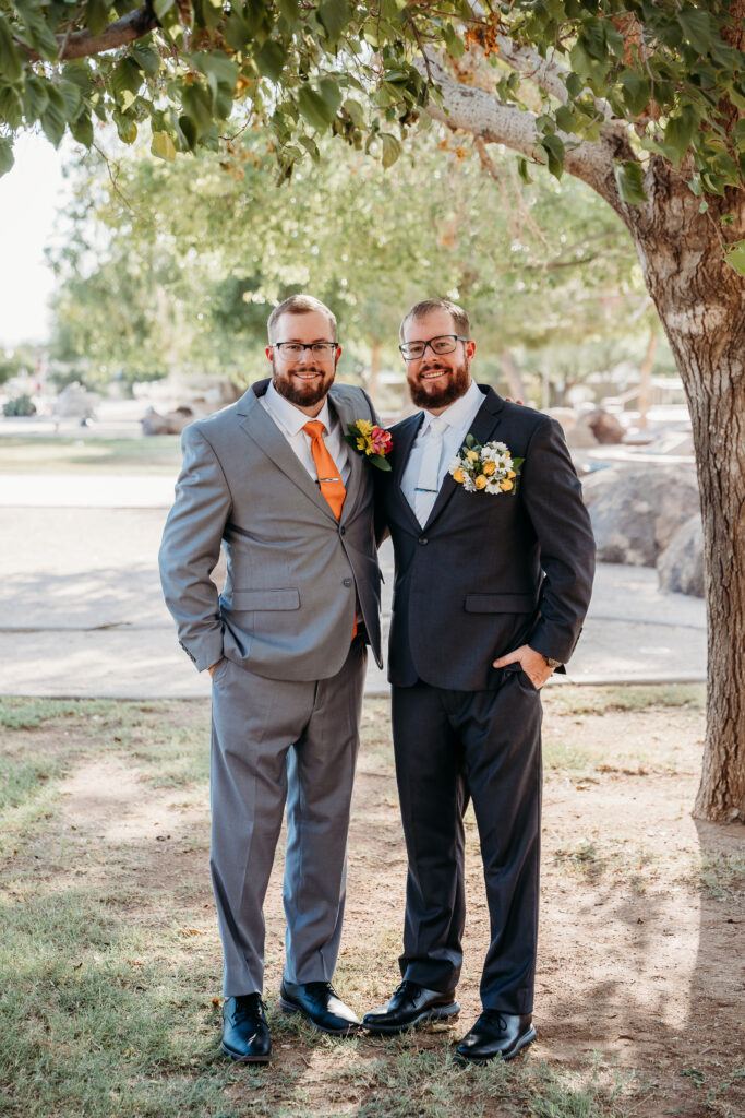 Groomsmen in grey tux and orange tie, bright boutonniere, wedding party posing ideas, arizona wedding photographer