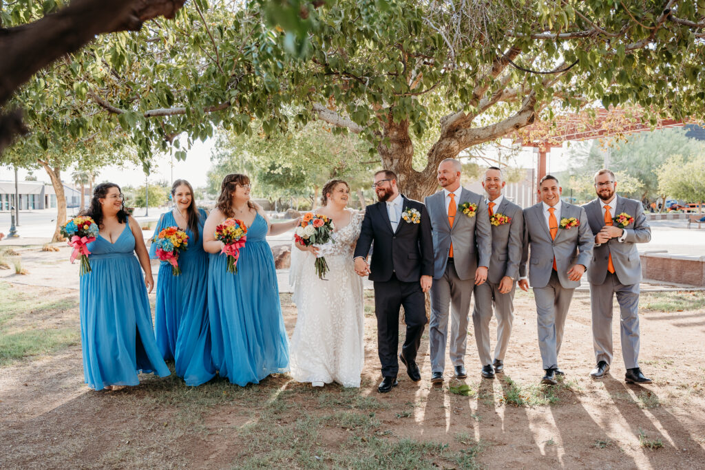 wedding party posing ideas, bridesmaid long bright blue dress, bright floral bouquets, gerber daisy and rose bouquets