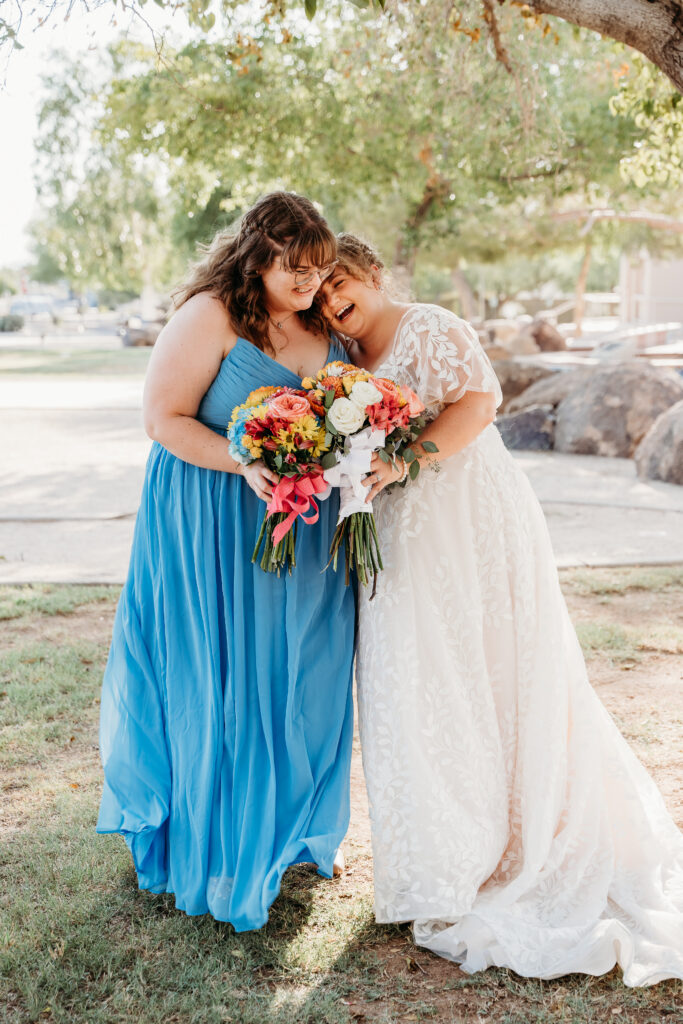 Bride and bridesmaid posing ideas, bridesmaid long bright blue dress, bright floral bouquets