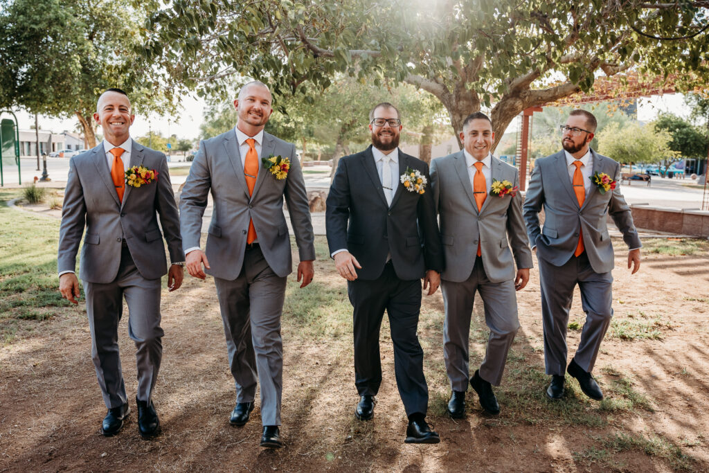 Groomsmen in grey tux and orange tie, bright boutonniere, wedding party posing ideas, arizona wedding photographer