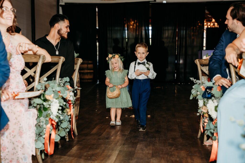 fire house event center ceremony, arizona wedding photographer, flower girl in sage green dress and ring bearer