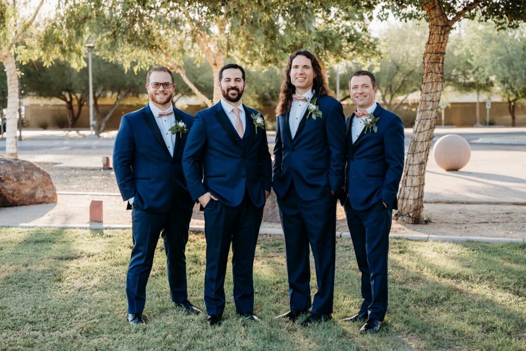 groom and groomsmen posing ideas, picking up groom, groom in navy blue tux