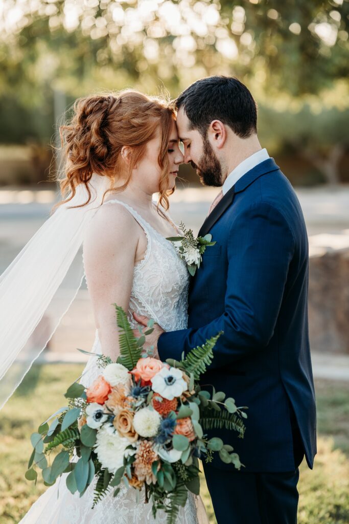 bride and groom posing ideas, arizona wedding photographer, groom in navy blue tux, bride in plunge neck line