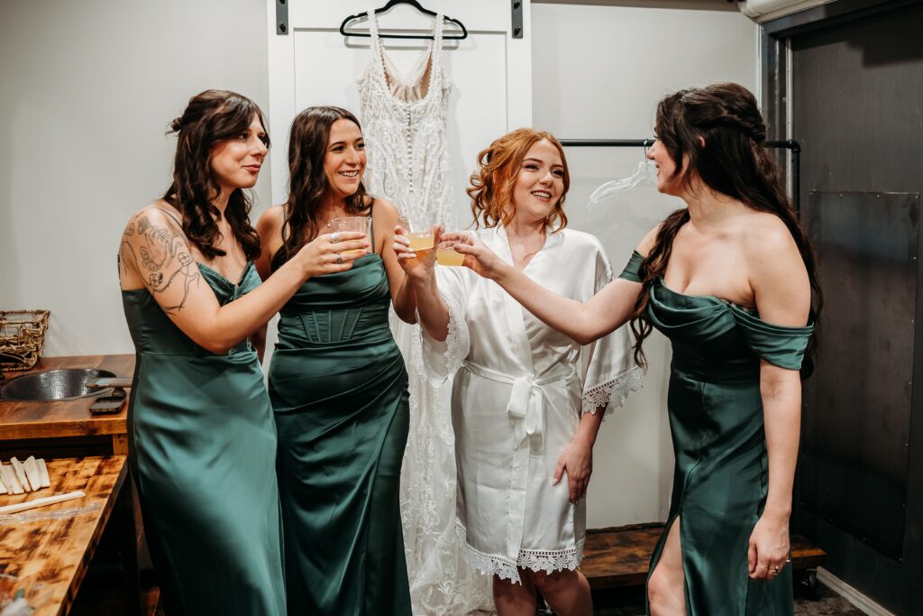 Bride getting ready at fire house even center with bridesmaids sharing a drink