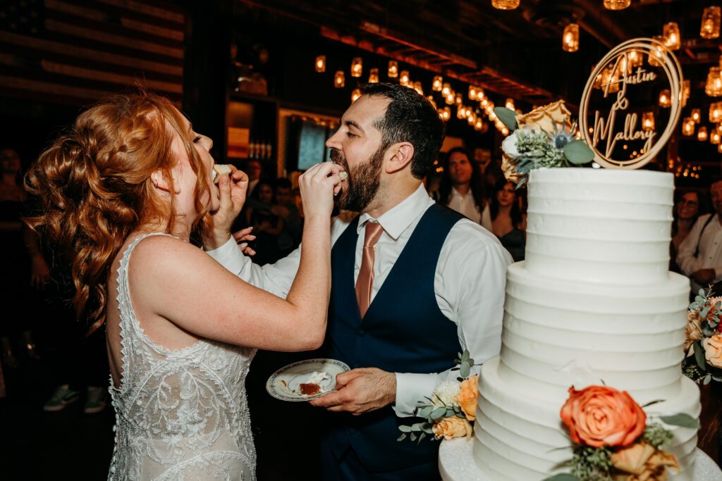 bride and groom cake cutting with gold cake top of names