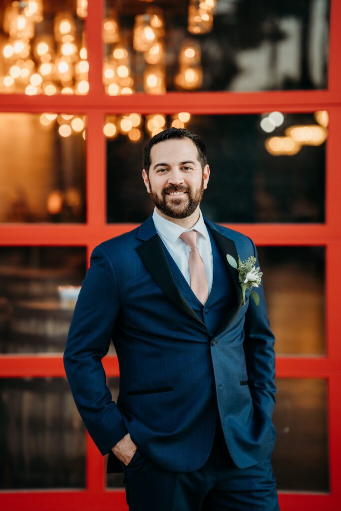 groom posing ideas, groom in navy blue tux with blush tie