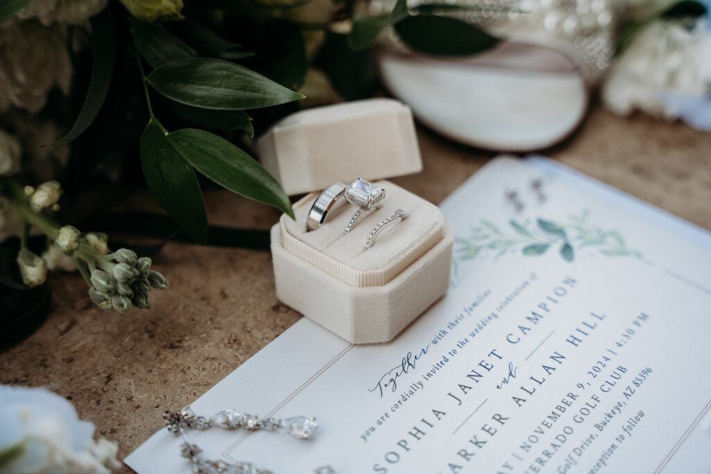 Wedding Flat Lay with wedding rings, wedding invitation and diamond drop earrings